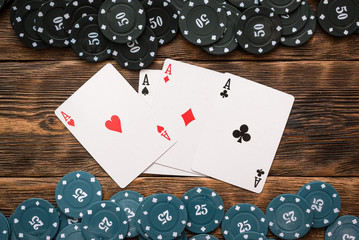 Wall Mural - Poker chips and four aces cards on wooden table background.