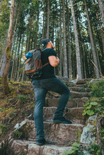Man With Backpack Walking By Stone Stairs That Leads To The Forest