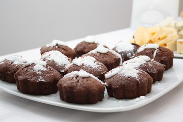 Chocolate muffins with icing sugar on a white plate