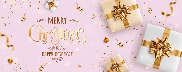 gold christmas and new year text on pink xmas background with gift boxes, fir branches, gold ribbon,