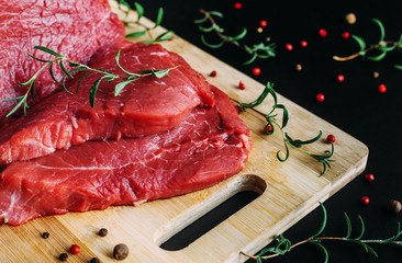 Wall Mural - Fresh and raw meat. Whole piece of red beef ready to cook on the grill or BBQ . Background black blackboard.