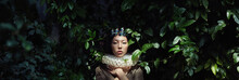 Art Portrait Of A Girl Princess Queen In Foliage And Greenery, Fabulous Romantic Image Of An Asian Woman In A Magical Dress. Sensual Gentle Glance. The Girl In The Palace Is Waiting For The Prince
