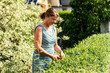 © Edler von Rabenstein - Woman with secateurs cutting the hedge