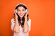 © deagreez - Portrait of positive cheerful girl listen music wear white head phone feel pleasure emotions wear stylish clothing isolated over shine color background