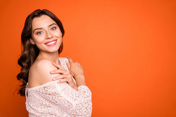 Wall Mural - Portrait of charming attractive girl hug herself enjoy luxury party look good wear knitted blouse isolated over orange color background