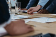 © LIGHTFIELD STUDIOS - cropped view of businesswoman pointing with pencil at document during business meeting with colleagues