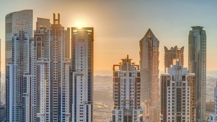  Modern residential and office complex with many towers aerial timelapse at sunset in Business Bay, Dubai, UAE.