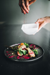 Michelin restaurant serving organic duck meat with kale and Beet puree on dark plate, chef cooking food