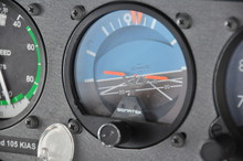 Single Engine Piston Aircraft Attitude Indicator Close Up Shot During Turn, Orange Indication With Blue Sky And Rate And Angle Of Turn