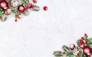 christmas decoration. frame of cones pine, twigs christmas tree, red balls, red berries on snow with