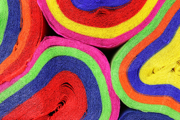  Close up coils of colorful crepe paper bunting of red, orange, yellow, green, blue and pink to make an abstract background