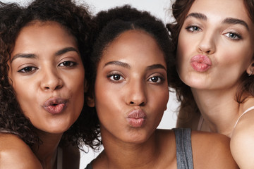 Wall Mural - portrait of multiracial women standing together and making kiss faces