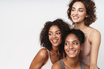 Wall Mural - portrait of three cheerful multiracial women smiling and looking aside