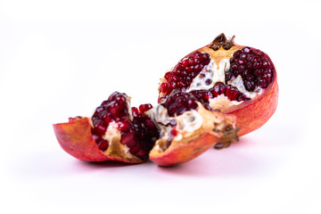 Two halfs of a pomegranate on white background with copy space