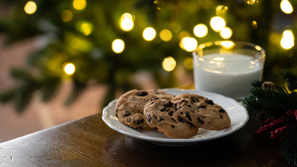 Christmas concept - cookies and milk left for Santa Claus, in front of christmas lights, bokeh