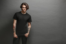 Hipster Handsome Male Model With Glasses Wearing Black Blank T-shirt And Black Jeans With Space For Your Logo Or Design In Casual Urban Style
