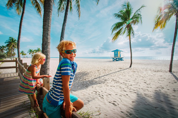 Poster - happy boy and girl looking at tropical beach with palms