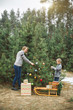 © sofiko14 - A mother and her child son decorate the Christmas tree outdoors, in winter forest. New Year decorations, wooden sledge with Christmas wreath, gifts under the tree