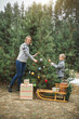 © sofiko14 - Winter and people concept - mother with child son decorate a christmas tree outdoors in the forest