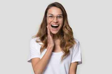 Wall Mural - Happy surprised young woman wearing glasses with open mouth