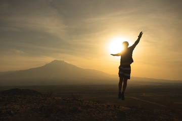 a man travels in Armenia, Yerevan. At sunset, she jumps silhouettes against the backdrop of Mount Ararat. Very beautiful landscape.