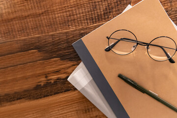 Notebooks, newspapers and glasses on wooden tables, work tables, display decorations,