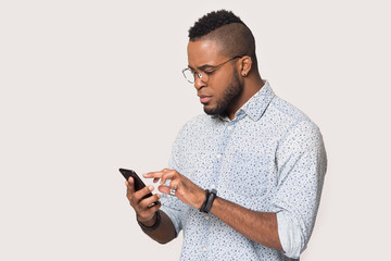 Serious African American man using phone isolated on white background