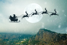 Santa Flying On Sky Over Over The Mountains. Marry Christmas And Happy Holiday.