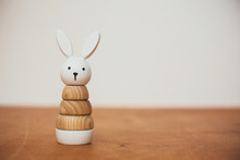 Stylish Wooden Toy For Child On Wooden Table. Modern  Wooden Bunny Pyramid With Rings. Eco Friendly, Plastic Free Toys For Toddler. Space For Text