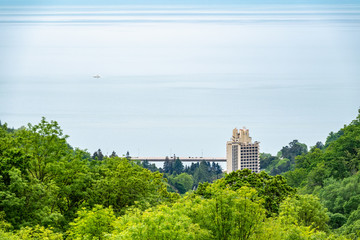 Green sea shore with residential buildings in the spring or summer day