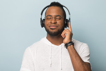 Calm African American Man In Headphones Enjoying Favorite Music