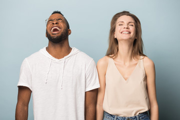 Happy diverse man and woman laughing at hilarious joke together