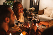 © Drobot Dean - Photo of people drinking wine and smiling while having Christmas dinner