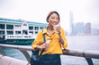 © BullRun - Young Asian woman smiling and holding coffee to go