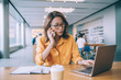 © BullRun - Attractive woman in trendy spectacles reading received email with project information while making cell conversation with customer service, Japanese female freelancer chatting via modern technologies