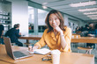 © BullRun - Smiling female freelancer writing at table in restroom