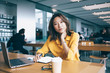 © BullRun - Portrait of tired Japanese hipster girl looking at camera during remote deadline in coworking space, skilled female student preparing to university exams using laptop computer for e learning