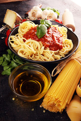 Tasty appetizing classic italian spaghetti pasta with tomato sauce, cheese parmesan and basil and ingredients