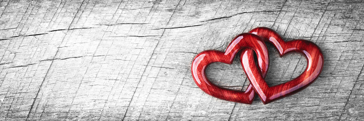 Wall Mural - banner of two red wooden interlocking hearts with high gloss finish on rustic wood table - valentine