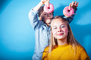 happy family brother and sister eating donuts on blue background, lifestyle people concept, boy and girl eating unhealthy food