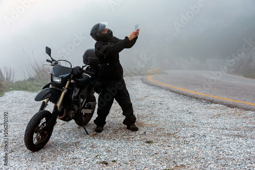 Fotomural Rider is trying to find signal on his mobile on a foggy day