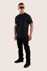 Wall Mural - A man wearing plain t shirt isolated on white background. Hipster man with tattoo wearing black t shirt, ready for mock up design template and background.