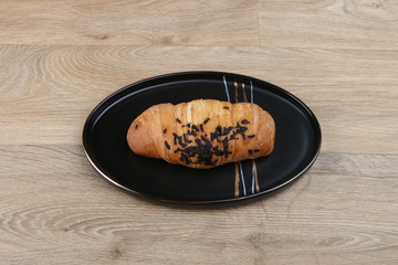 chocolate croissant on a black plate on a wooden background 