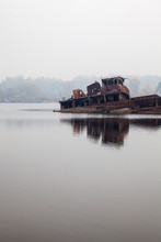 Old Sunken Ship In Water In A Foggy Day