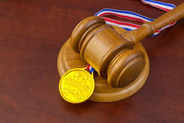 Medal and wooden judge's gavel, arbitration court concept.