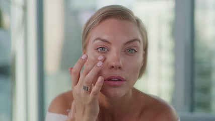 beauty blogger applying make up, looking in mirror, moisturizing lipstick, close up of face features