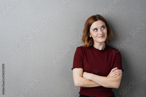 Fotomural Pretty young woman standing thinking with a smile