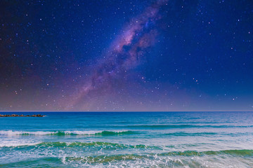 Wall Mural - night sky, milky way galaxy stars and space with sea or ocean and waves at the beach.
