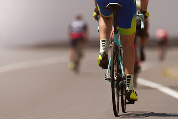 Wall Mural - Cycling competition cyclist athletes riding a race at high speed, detail on gear wheels and feet	