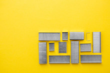 Metal Staples For Stapler On Yellow Background. Top View. Minimalistic Concept. Copy, Empty Space For Text